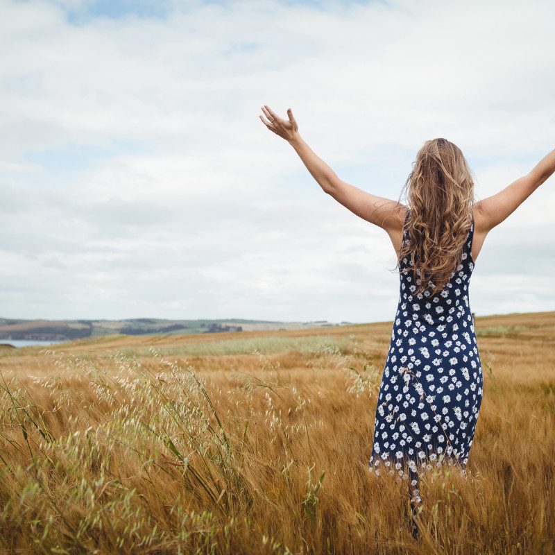 rear-view-woman-standing-with-arms-outstretched